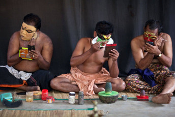A group of Kathakali actors put on heavy make-up on their faces before the commencement of their evening show at the Kathakali Centre in Kerala, India. © Zzvet

10 Two lifeguards sitting under the shade of an umbrella on a scorching sunny day on the beautiful beach in Kovalam, Kerala, India. © Ajayptp