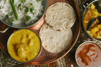A plate full of the most popular items of the vegetarian Gujarati cuisine, including the kadhi that is served with rice. © PI