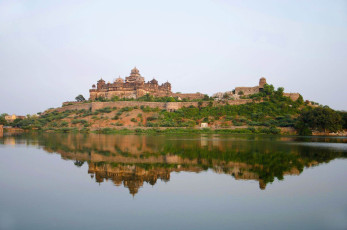 Seven-floor Datia Palace, the largest and most impressive of the 52 palaces built by Raja Bin Singh Deo, is beautifully reflected in the lake, Madhya Pradesh / Tiger Safari Tour India