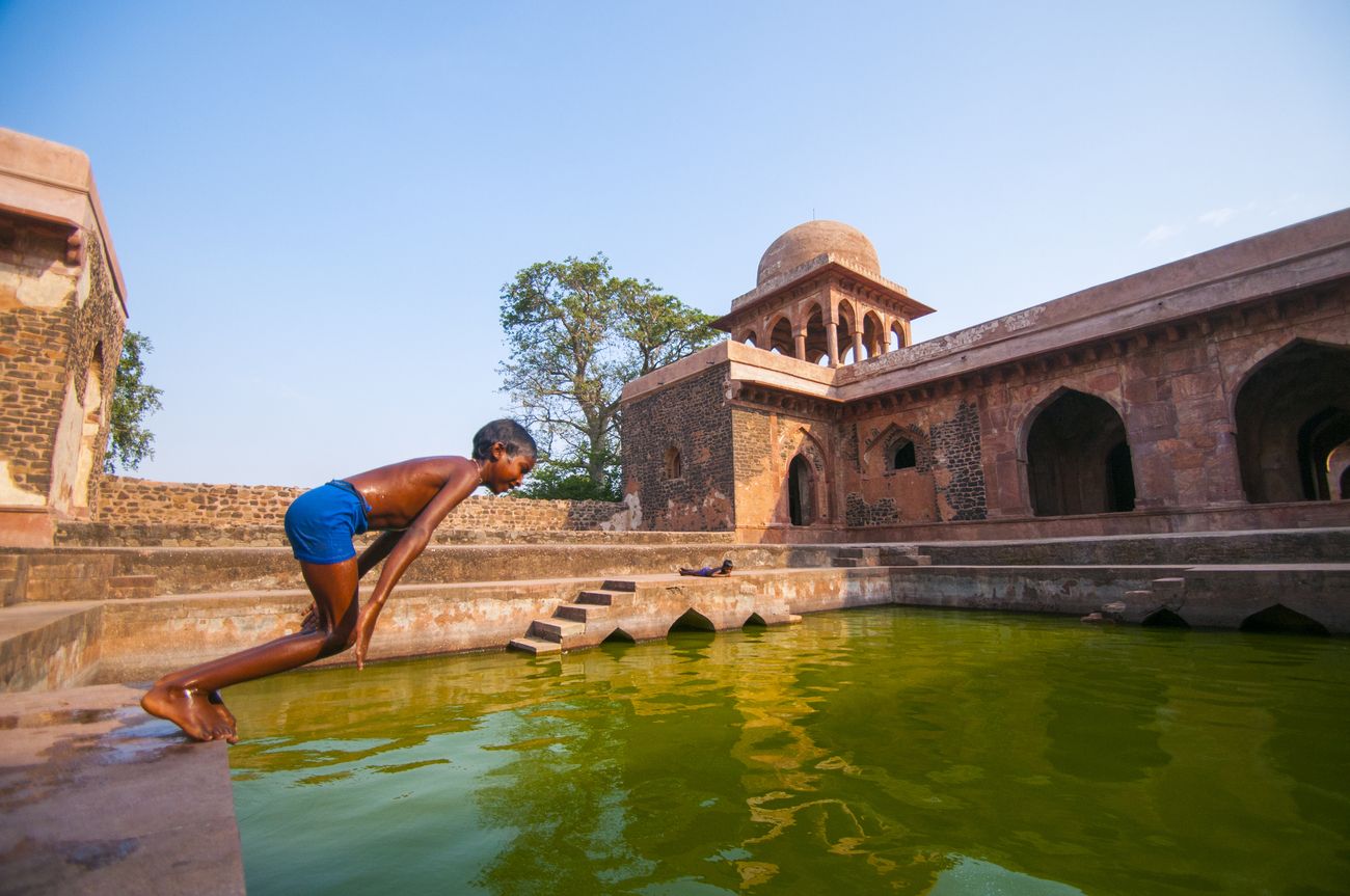 At Baz Bahadur Palace, this young lad takes a swim. Major tourist attraction in Mandu, destination for tourist, INDIA