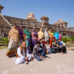 Indian visitors being photographed in the backdrop of the Ship Palace, Jahaz Mahal in Mandu