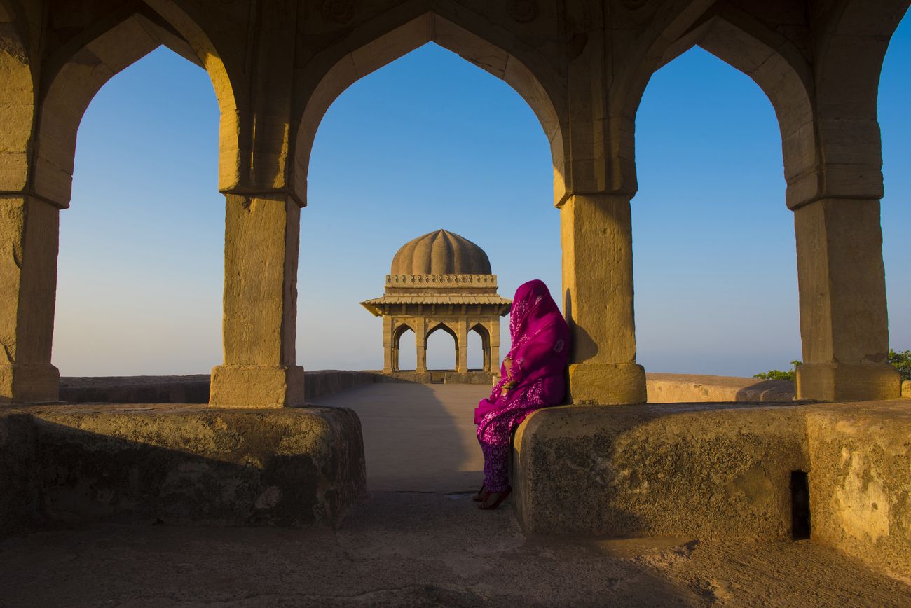 Veiled woman sitting at Rani Roopmati dome and Palace an old fort city in Mandu Madhya Pradesh India