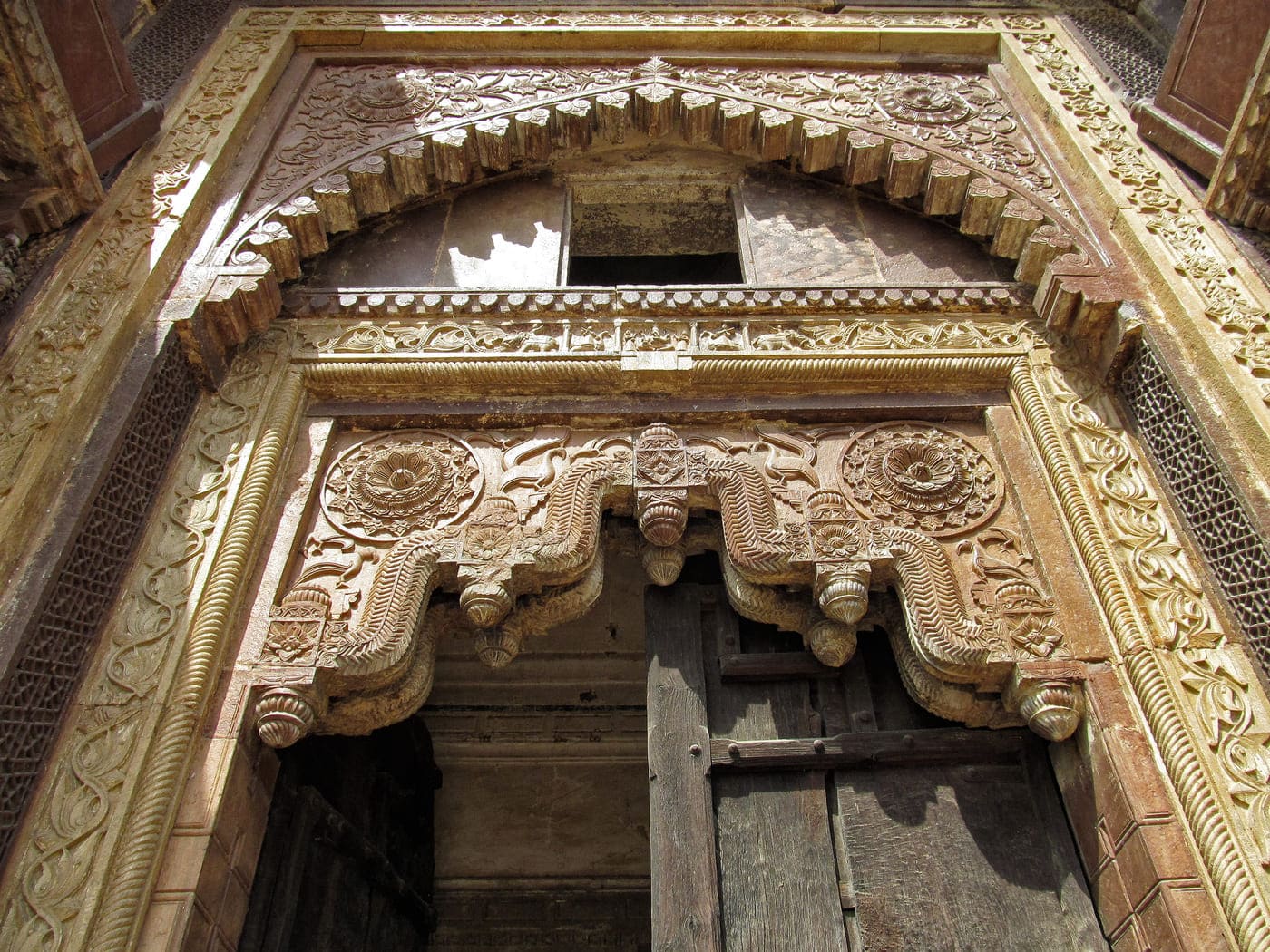 A close up view of the main entrance of the Jahangir Palace shows the detailed stone-carving artwork generally associated with Mughal decor but adapted by use of HIndu imagery and designs, Orchha 