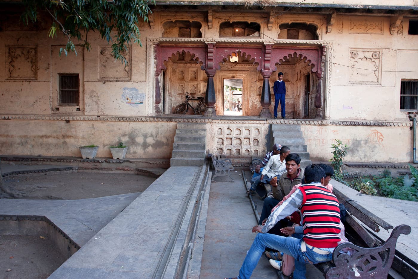 A group of Indian teenagers meet up in the old city garden in Orchha, Madhya Pradesh, India. The place attracts both locals and tourists alike because of its unique architeture