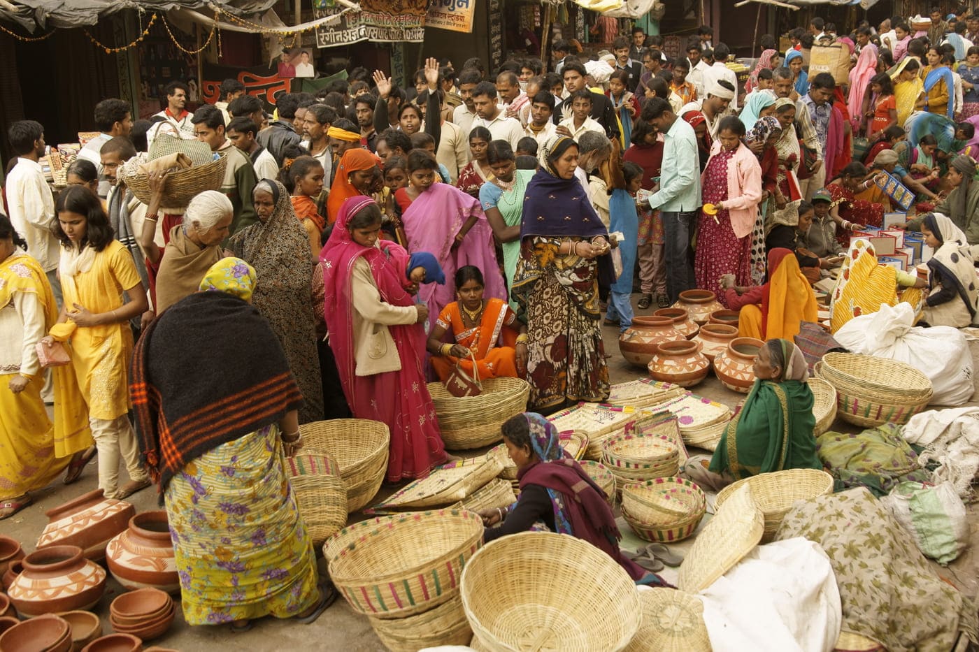 A scene from a village market in Orchha where women are selling handmade cane baskets and earthenware 
