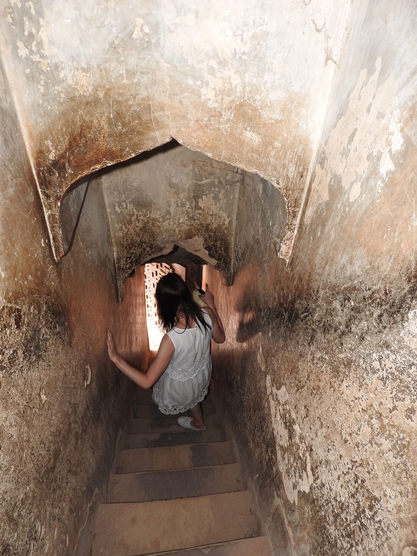 A visitor at the Jahangir Palace in Orchha carefully steps down the steep stairs that date back to the early seventeenth century 