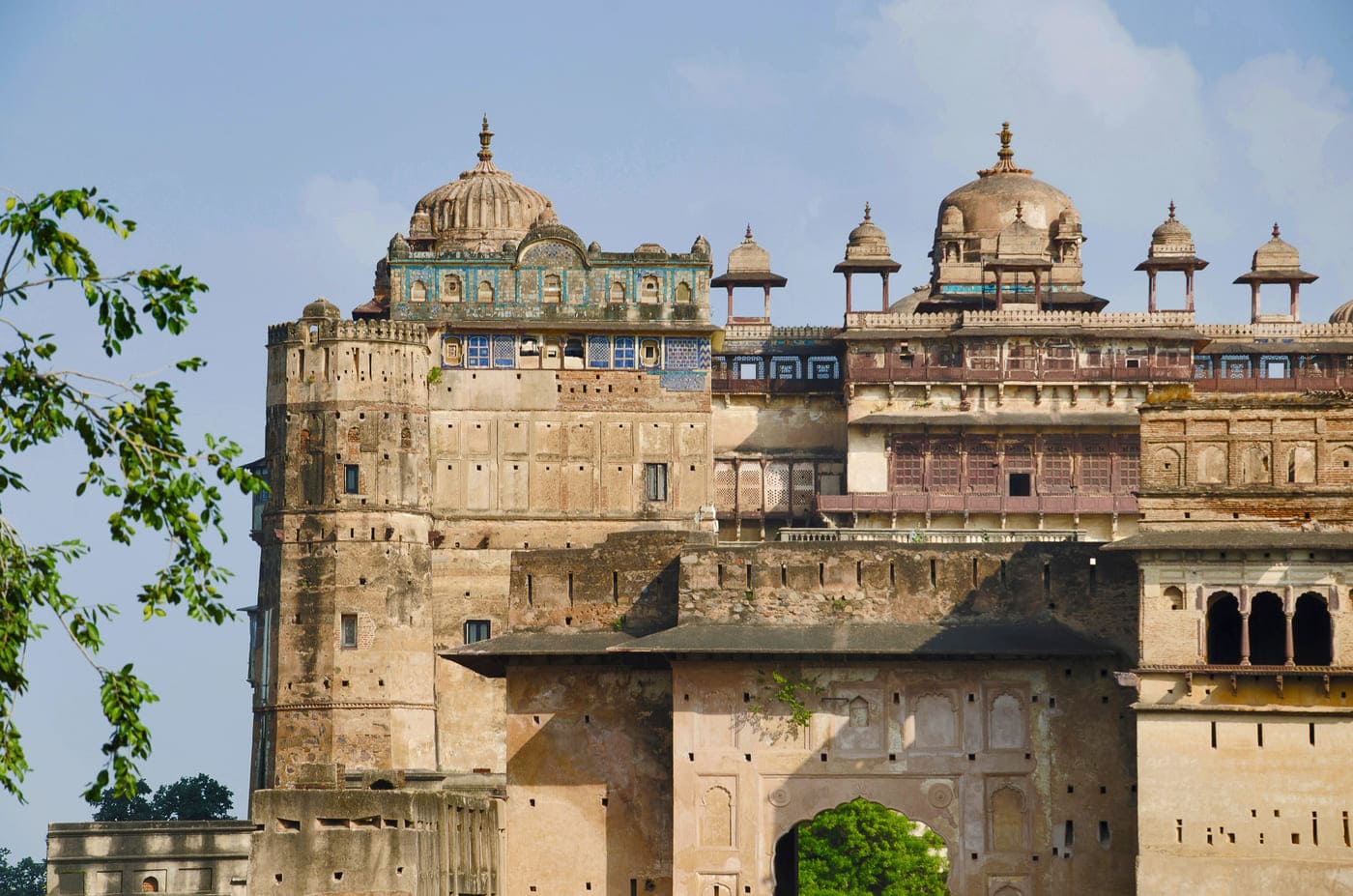 Exterior view of the Sheesh Mahal Heritage Hotel, with the domes of Jehangir Mahal visible in the background, situated in Orchha 