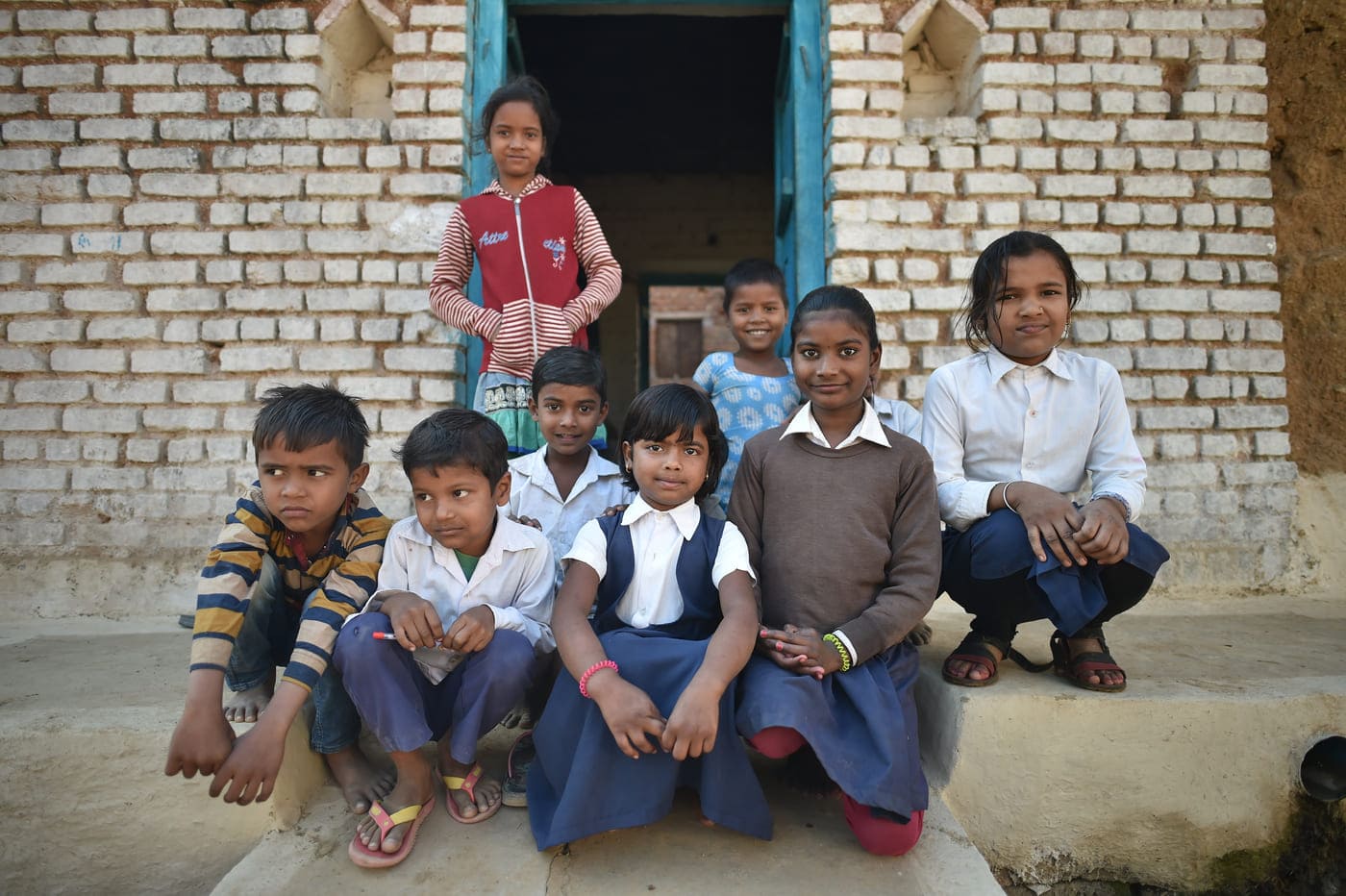 Kids striking a pose outside their house nearby Orchha 