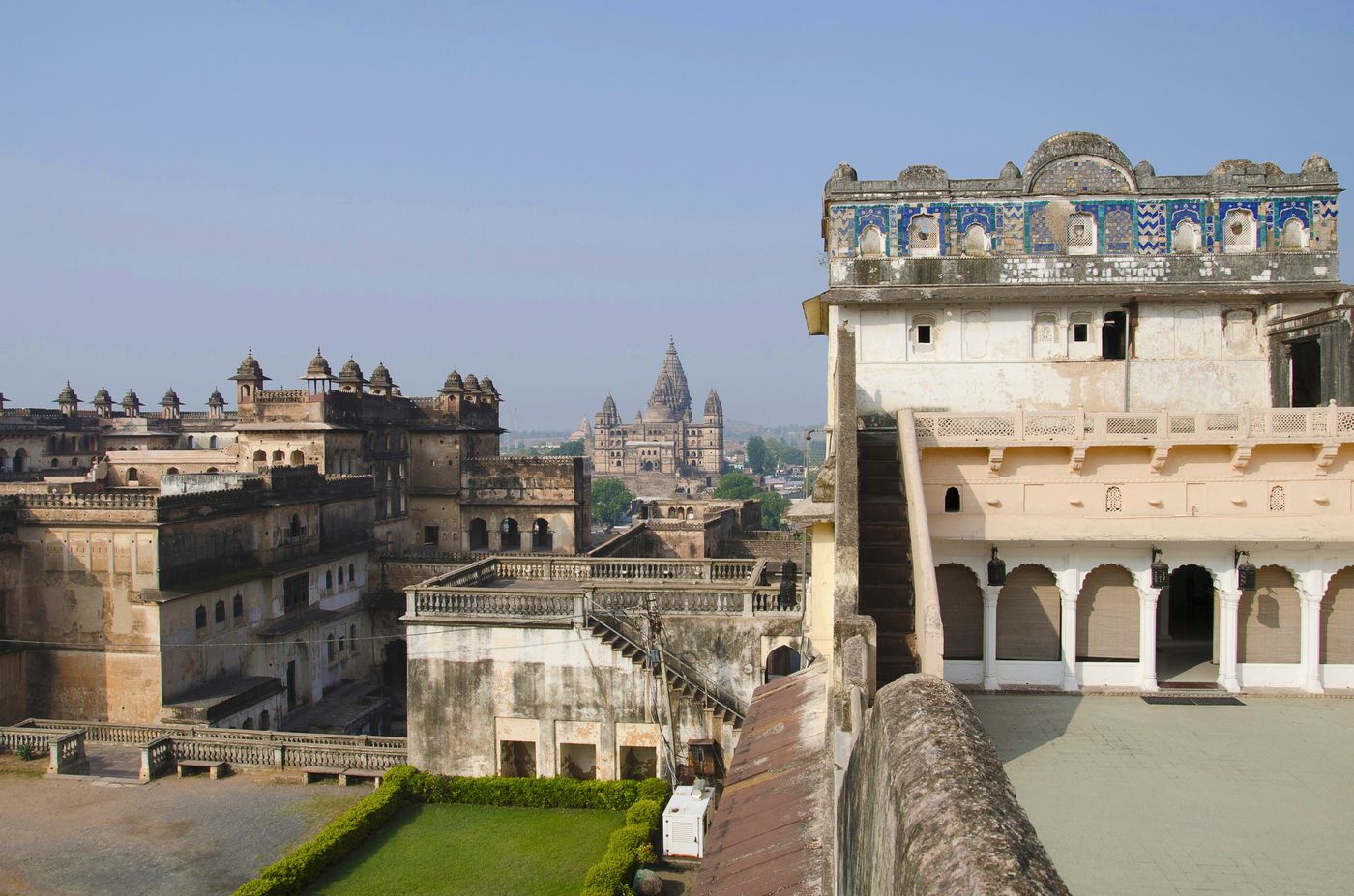 Terrace of the Sheesh Mahal Heritage Hotel. On left is Jahangir Mahal with round cupolas. In backgorund you can see the spirals of the Chaturbhuj temple © RealityImages