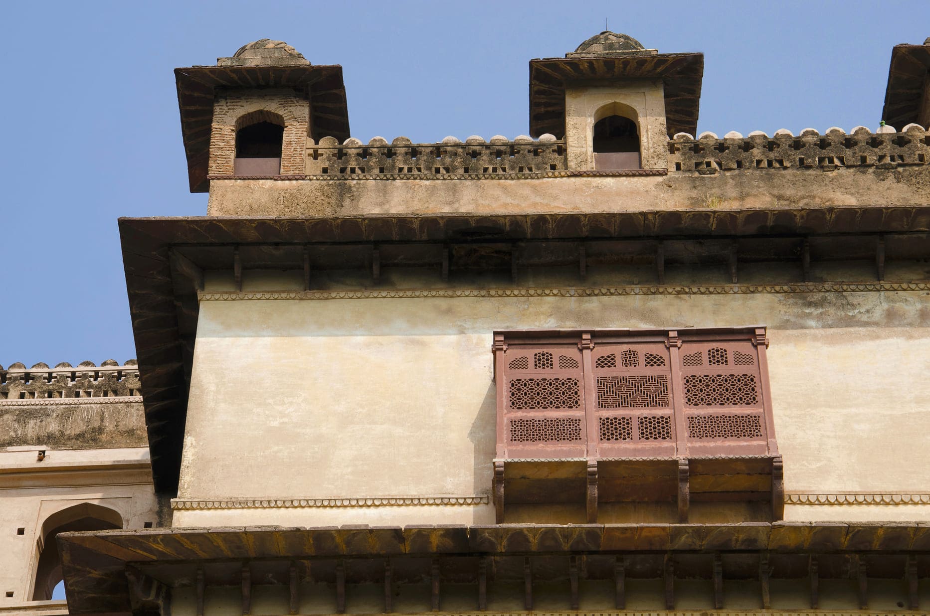 The intricately carved hanging balconies or jharokhas of Raj Mahal located in the Orchha Fort complex 