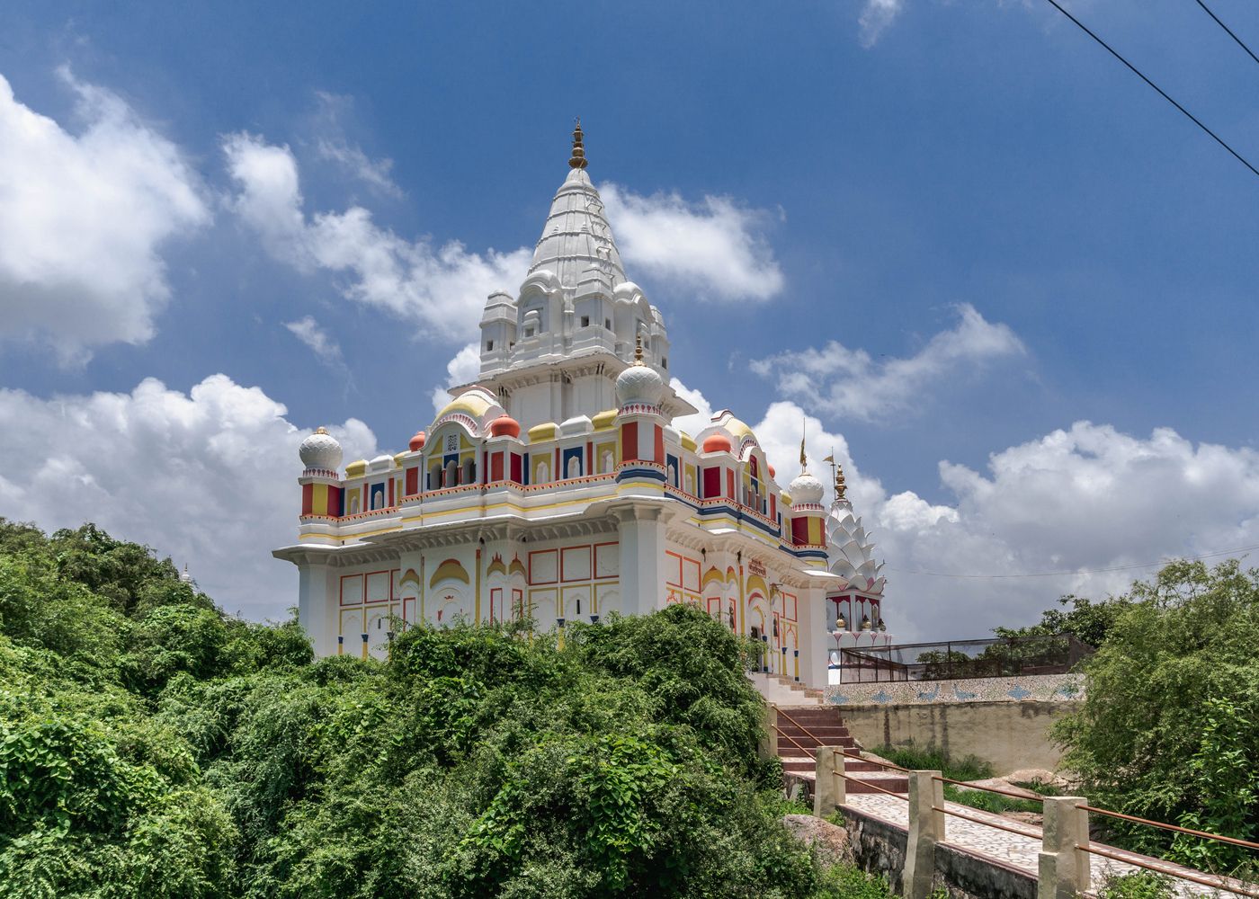 The side view of a majestic Jain temple, with high spires and hanging balconies, situated in Sonagiri 