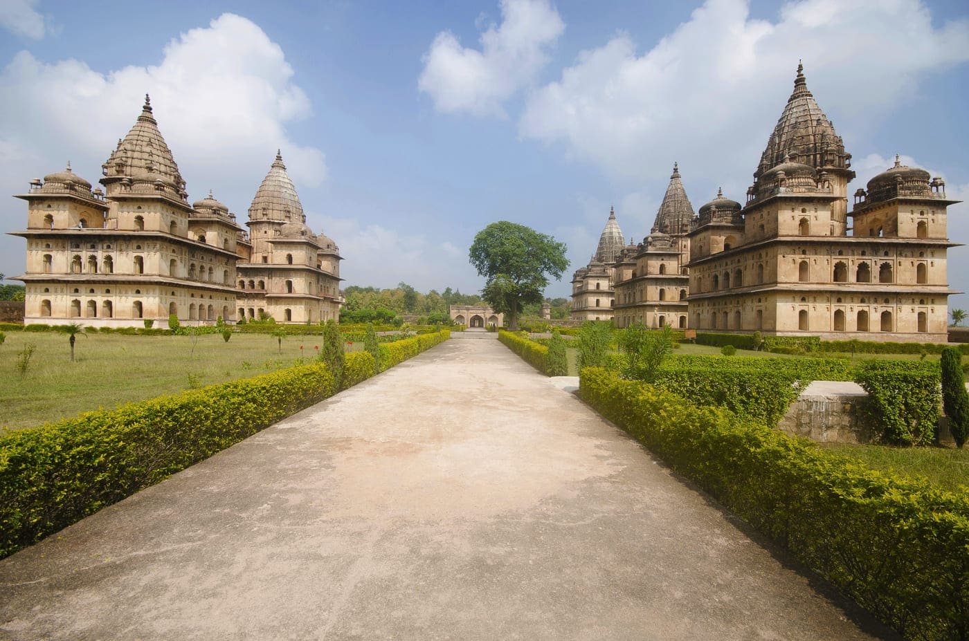 The wide path laden between the cenotaphs, the royal structures dating back to the fifteenth century, looking over the structures and the greenery around, Orchha