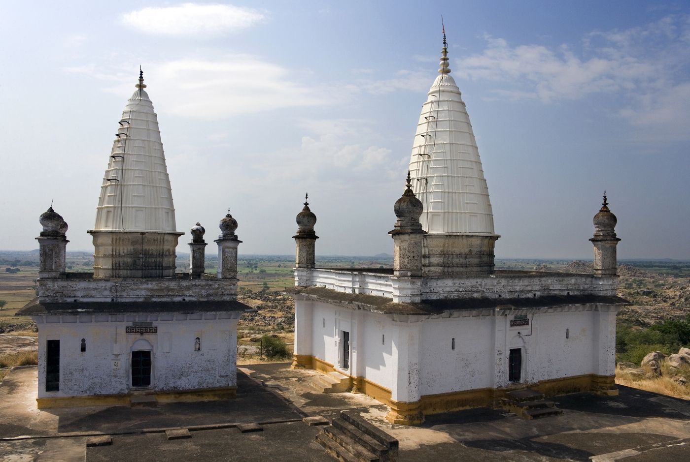 Two Jain temples overlooking the village in the Sonagiri Jain Temple complex and their high white spires facing the sky