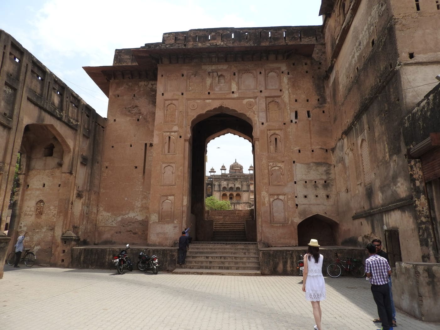 Visitors stand overlooking the second layer of fortification of the Orchha fort complex admiring the unique architectural style 