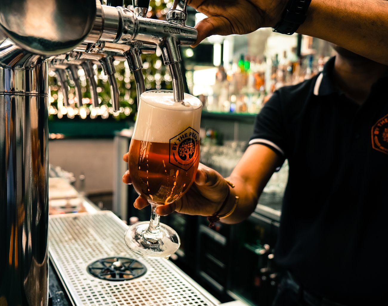A bartender pouring crafted beer in a local microbrewery