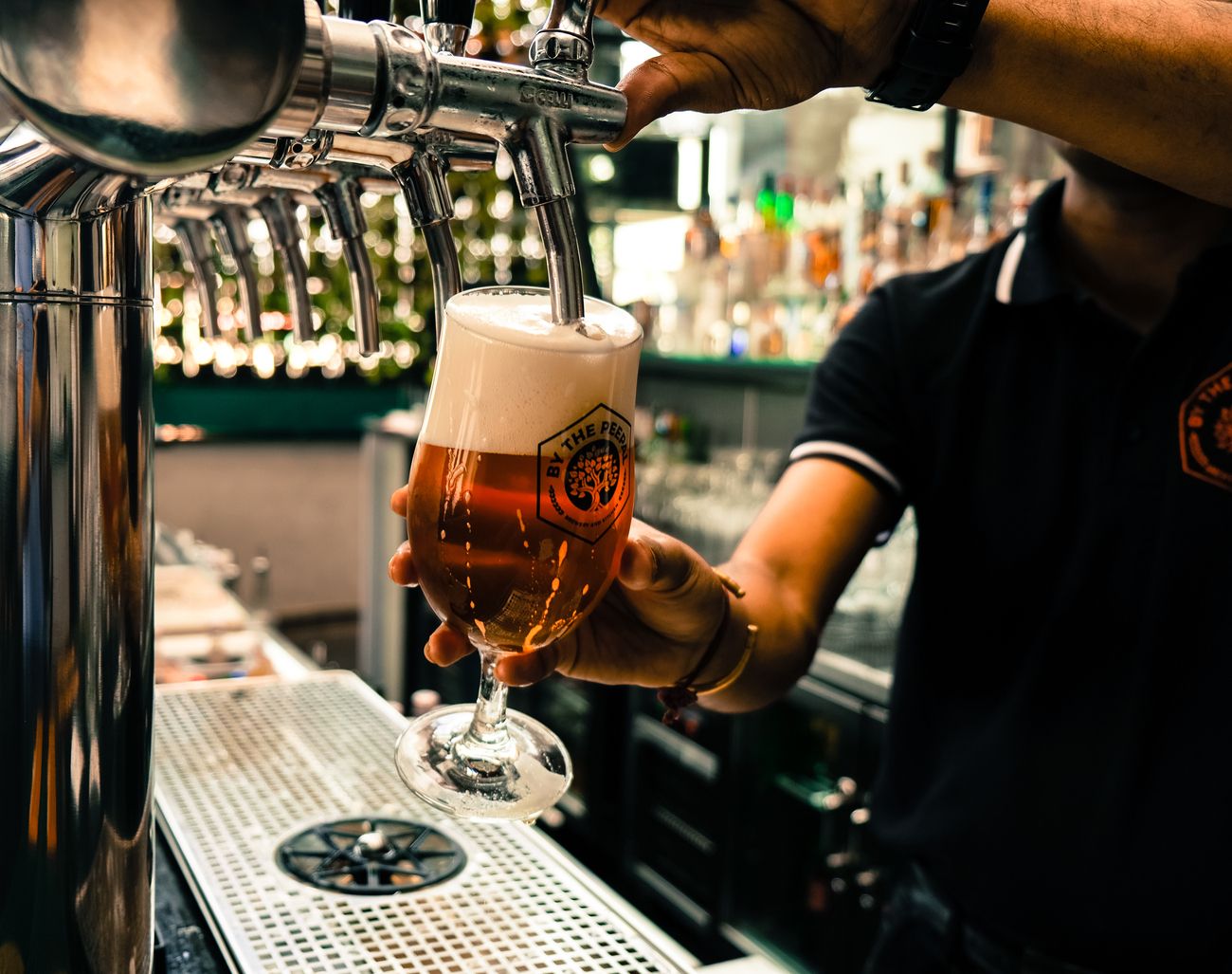 A bartender pouring crafted beer in a local microbrewery 