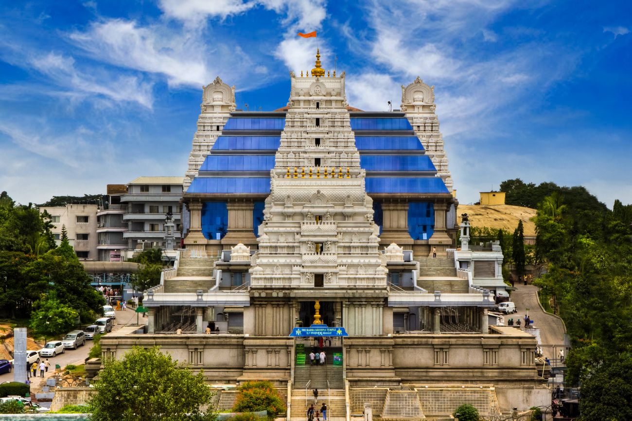 A grand view of the gorgeous ISKCON Krishna Temple under the clear blue sky. It is one of the most peaceful places in the city with good maintenance