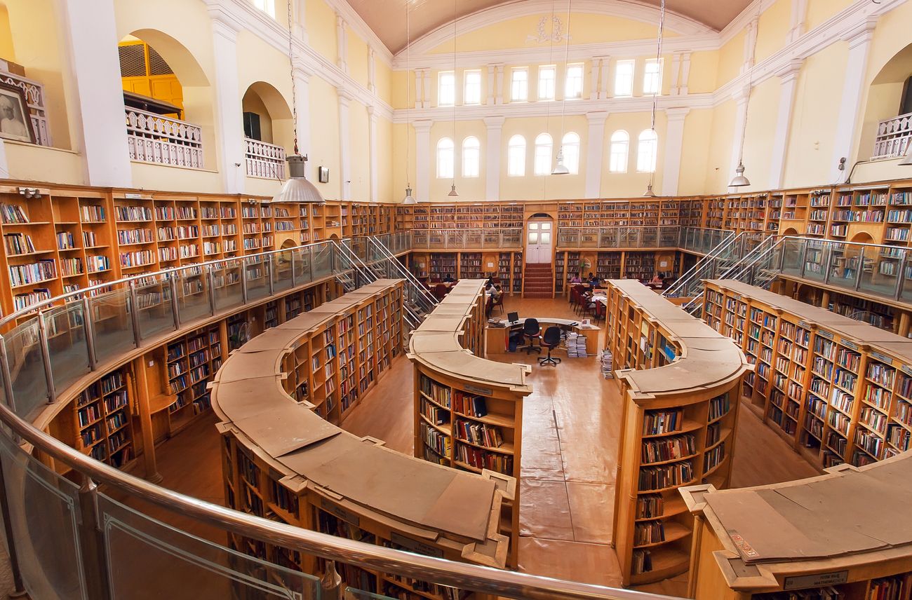 A huge wide hall of the Karnataka State Central Library Street embellished with old wooden bookshelves. With its Gothic-style architecture and housed with 2.500.000 books, the library continues to serve as a reference library with no borrowing allowed