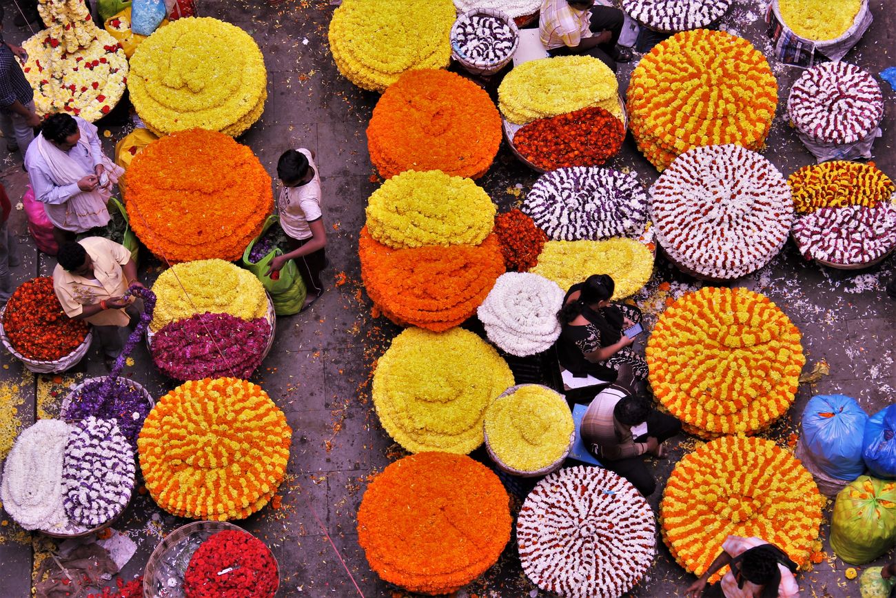 A luscious colorful flower market with a huge number of flower garlands stall sellers on the streets of Bangalore 