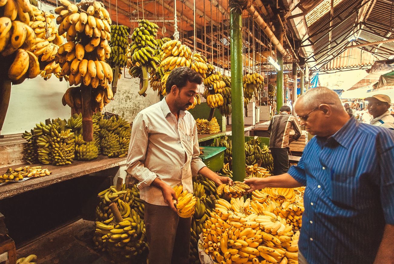 A street shop of a banana seller where a customer bargains at the farmer’s fruit market in the city. The Silicon Valley of India, Bangalore is the third most populous Indian city with a population of 8.52 million