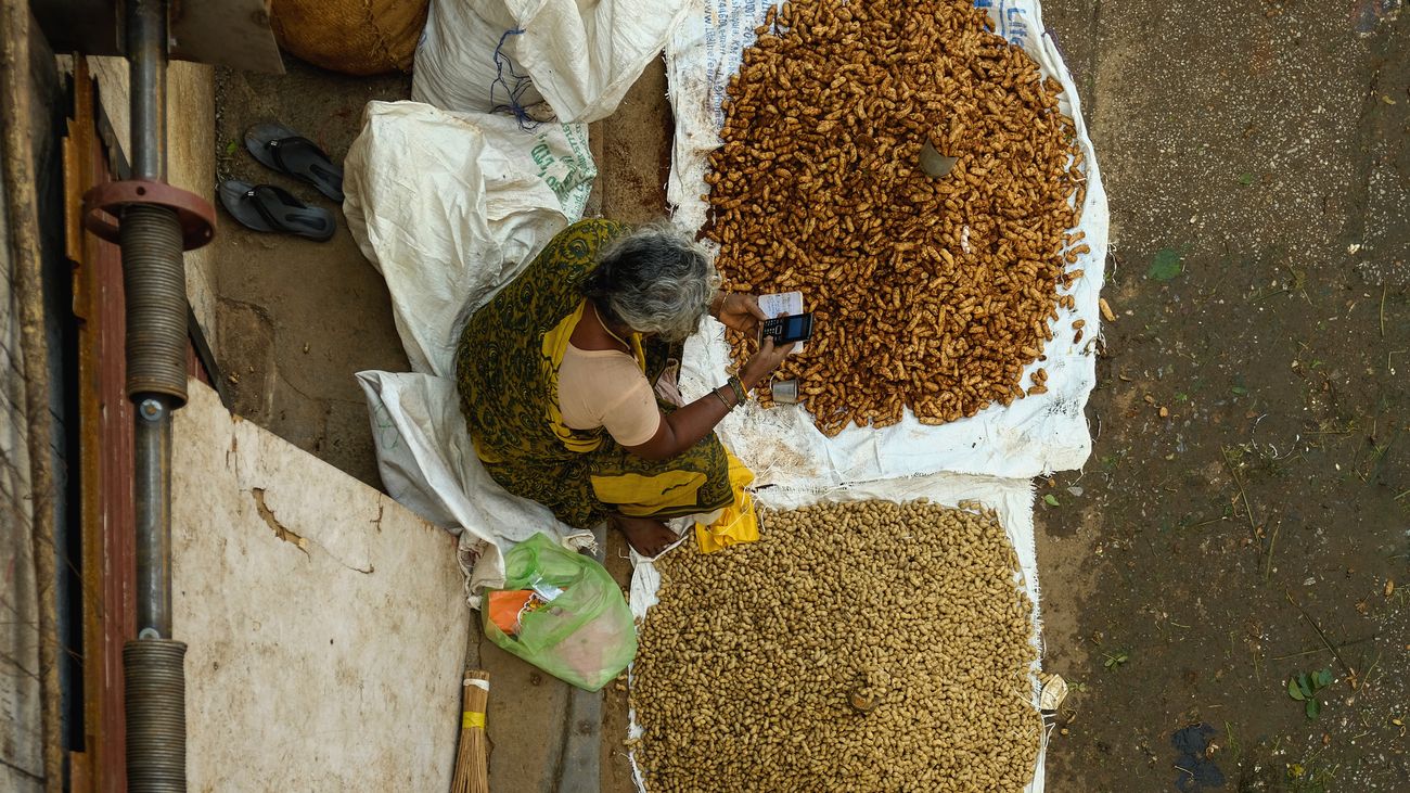 A Woman sells raw peanuts at KR Market which is also known as City Market. It is the largest wholesale market which dispenses commodities