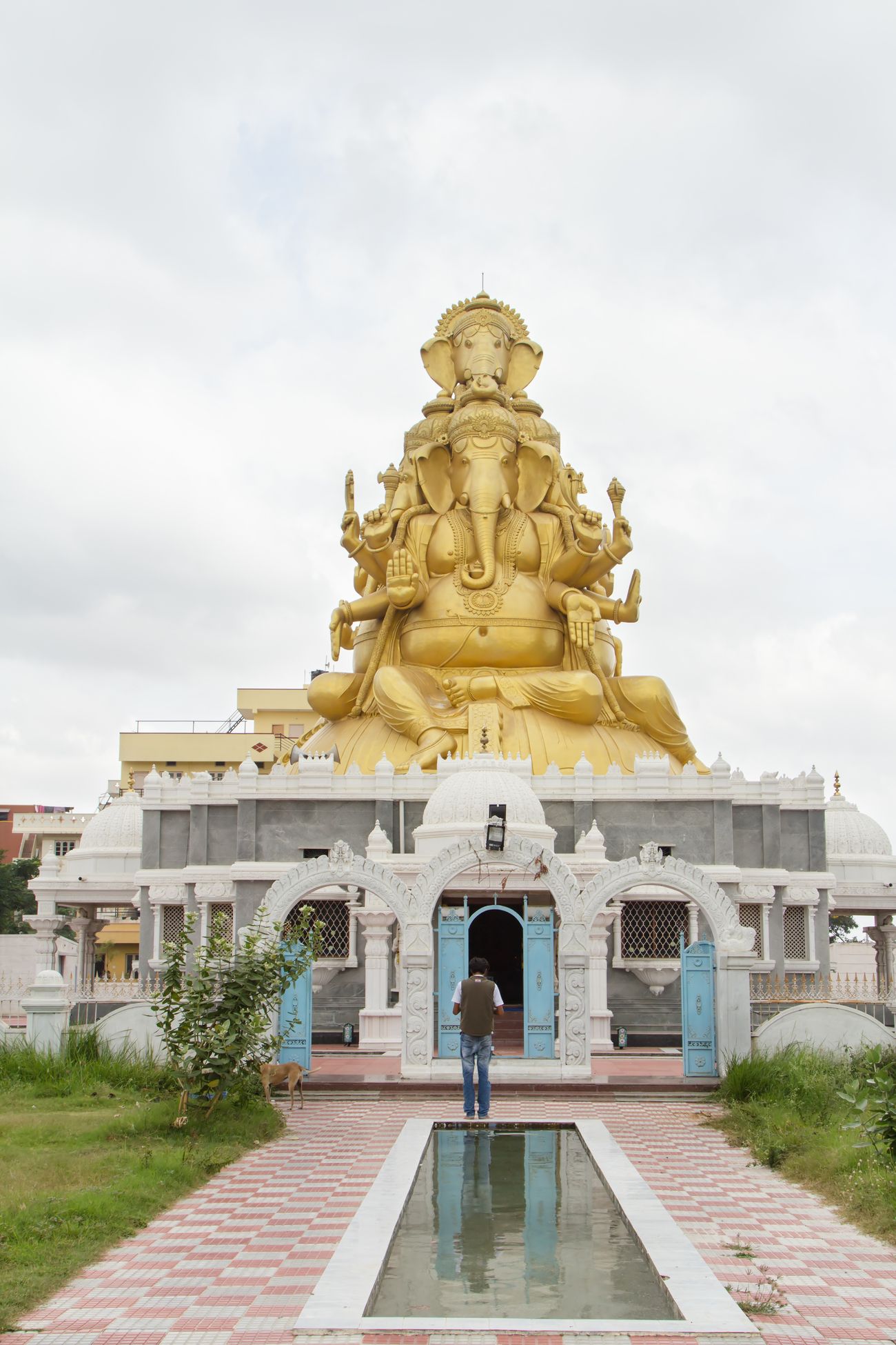 An Indian devotee stands and worships the giant statue of Ganesha, one of the most widely worshipped deities in Hindu religion, on the outskirts of Bangalore. This huge statue of Ganesha on the Bangalore-Mysore road is five-faced