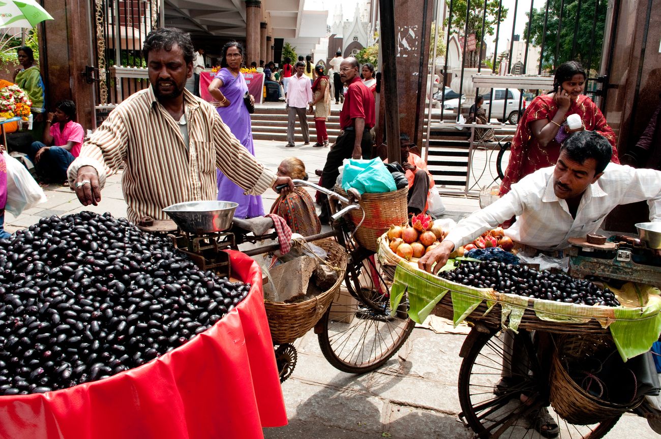Fruit vendors selling fruits loaded on their bicycles on an unnamed street in Bangalore. Approximately, 42% of India falls below the international poverty line of $1.25 a day