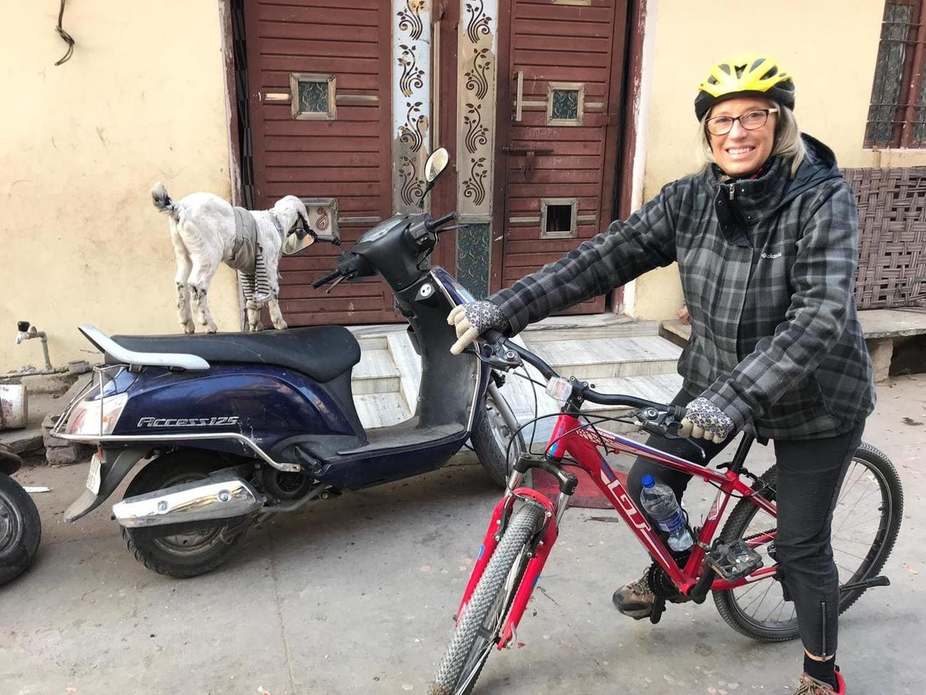 Guest posing with her bicycle in front of a house in Jaipur 