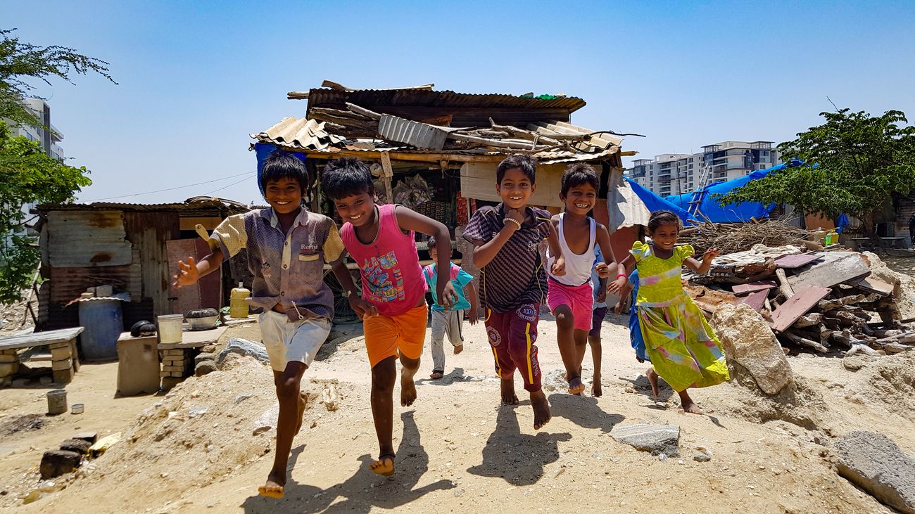 Kids joyfully running and playing in front of a shack shop that sells condiments in the city