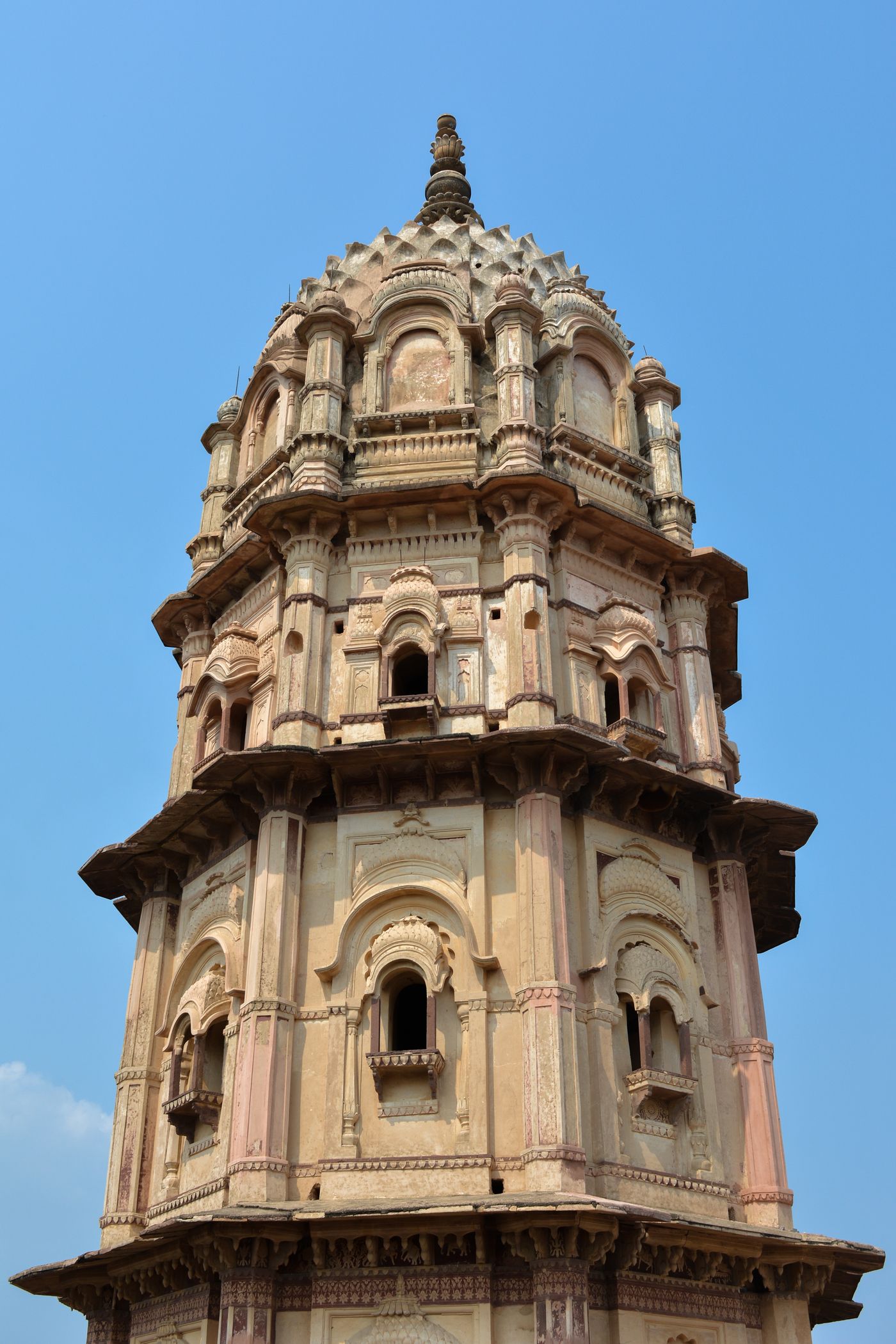 The high domed octagonal watchtower of Lakshmi Narayan Temple in Orchha, lined with false balconies and cannon openings.