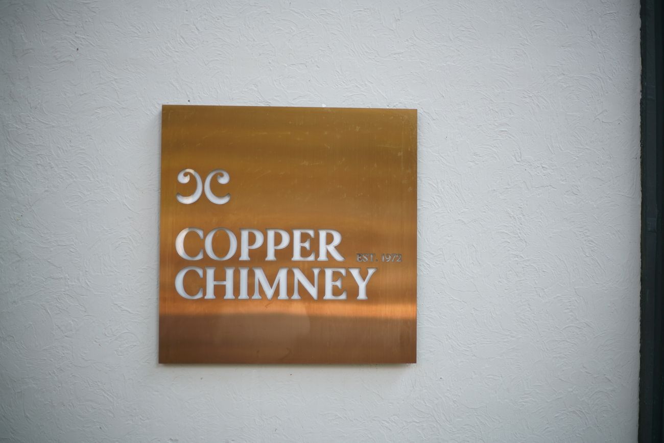 A zoomed in view of the trademark brand logo of Copper Chimney Restaurant outside the wall of their restaurant at the Kala Ghoda area, Fort, Mumbai