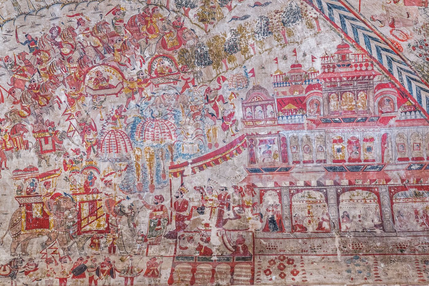 This painting shows how maharajas were welcomed back to their palaces after a victorious war. Ladies from the palace form a procession, the queens are watching from the windows, people play musical instruments, and sages perform Yajna, the fire worship, Orchha 