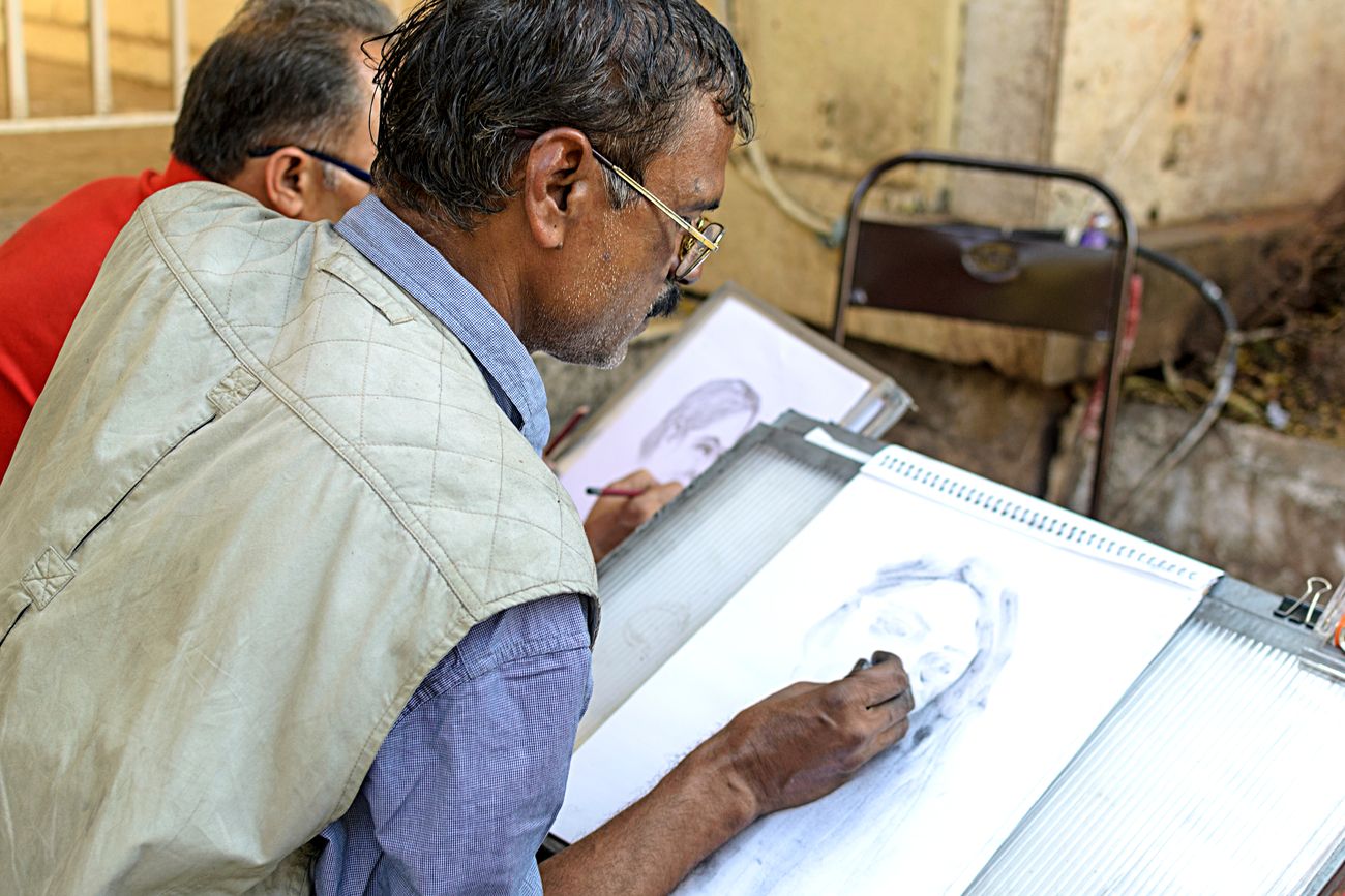 Two artists sketching portraits of people at The Kala Ghoda Arts Festival 