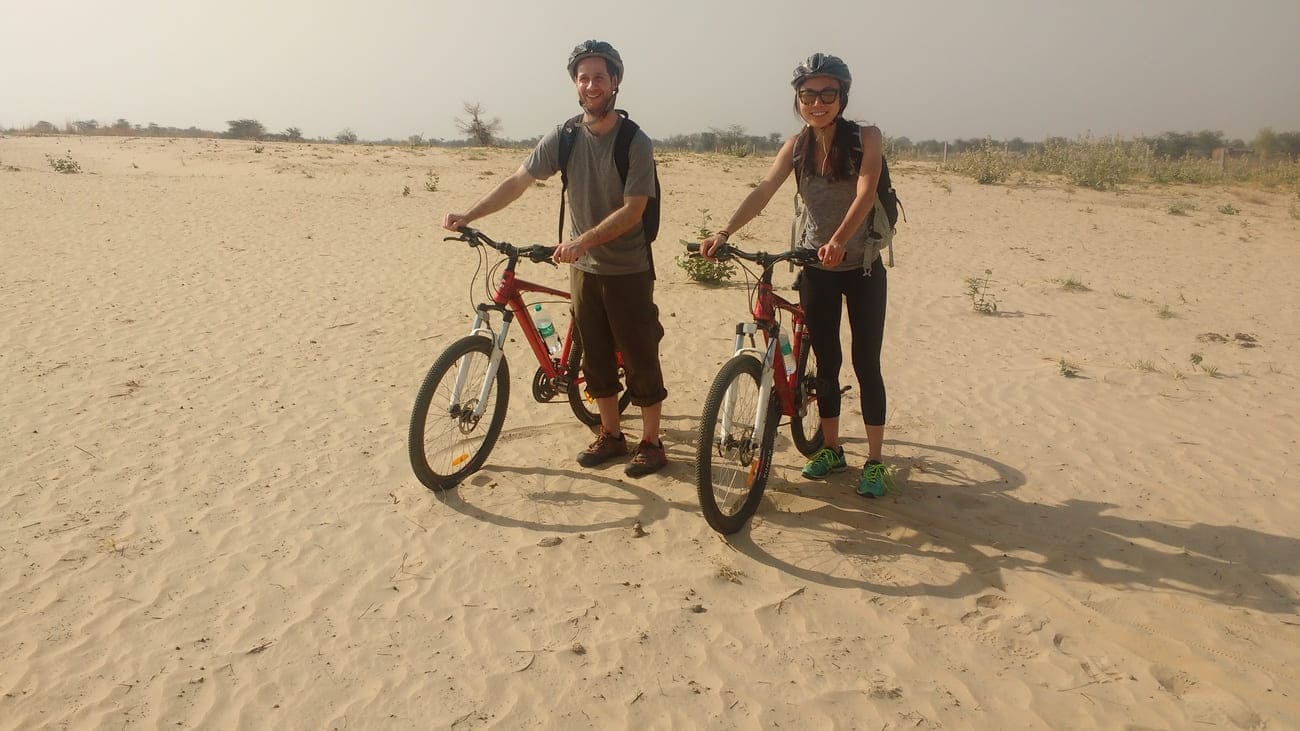 Two young cyclists cast their shadows on the desert-like landscape