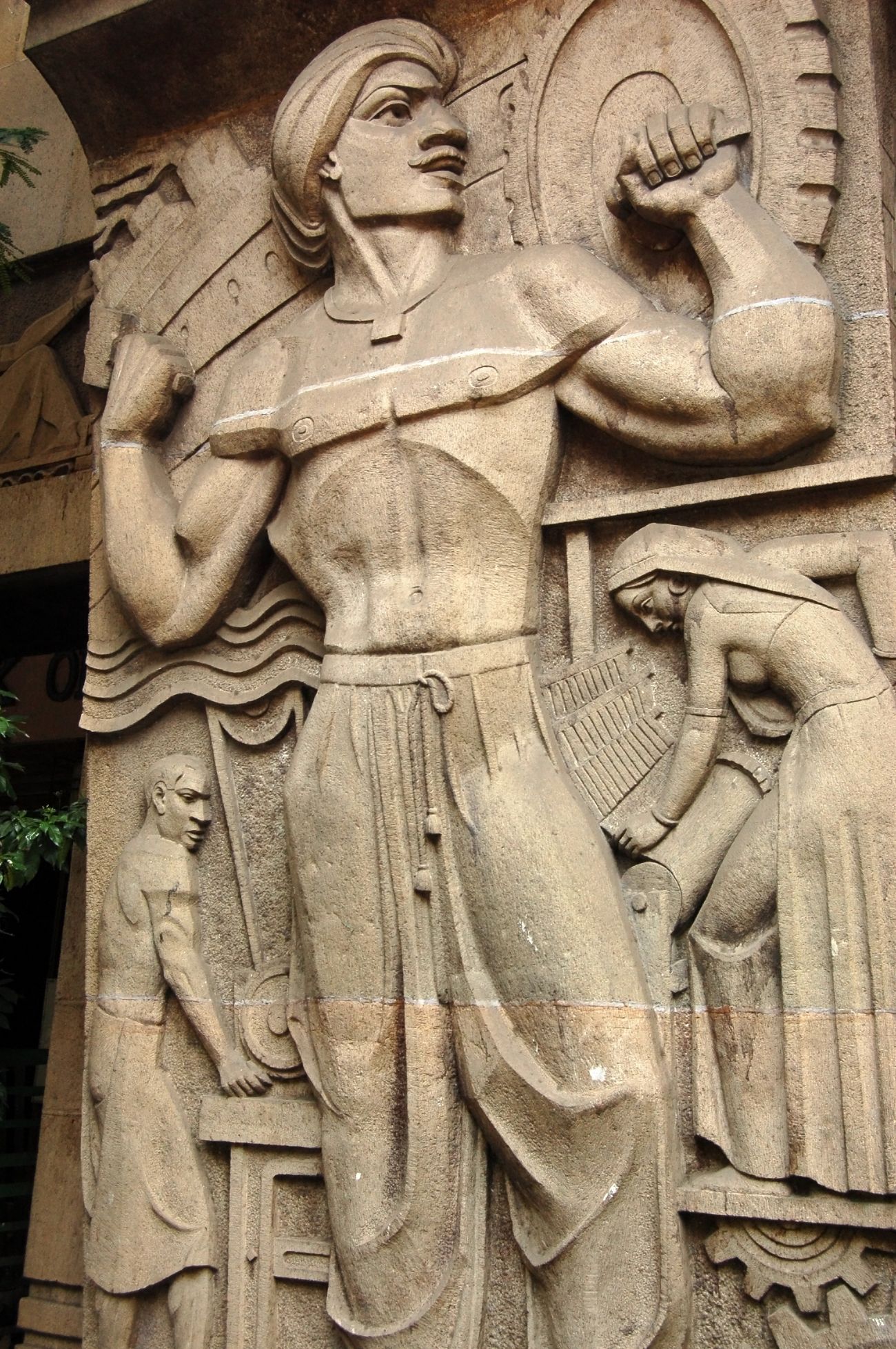 A 70 year art deco stone carving by the public pavement in Mumbai that depicts the hardworking industrial man. Mumbai has long been a hub of merchants and industry men, especially since it is a port