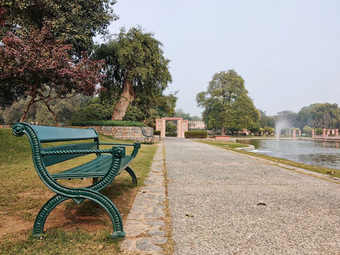 A bench beside the walking path surrounding the lake at Sunder Nursery 
