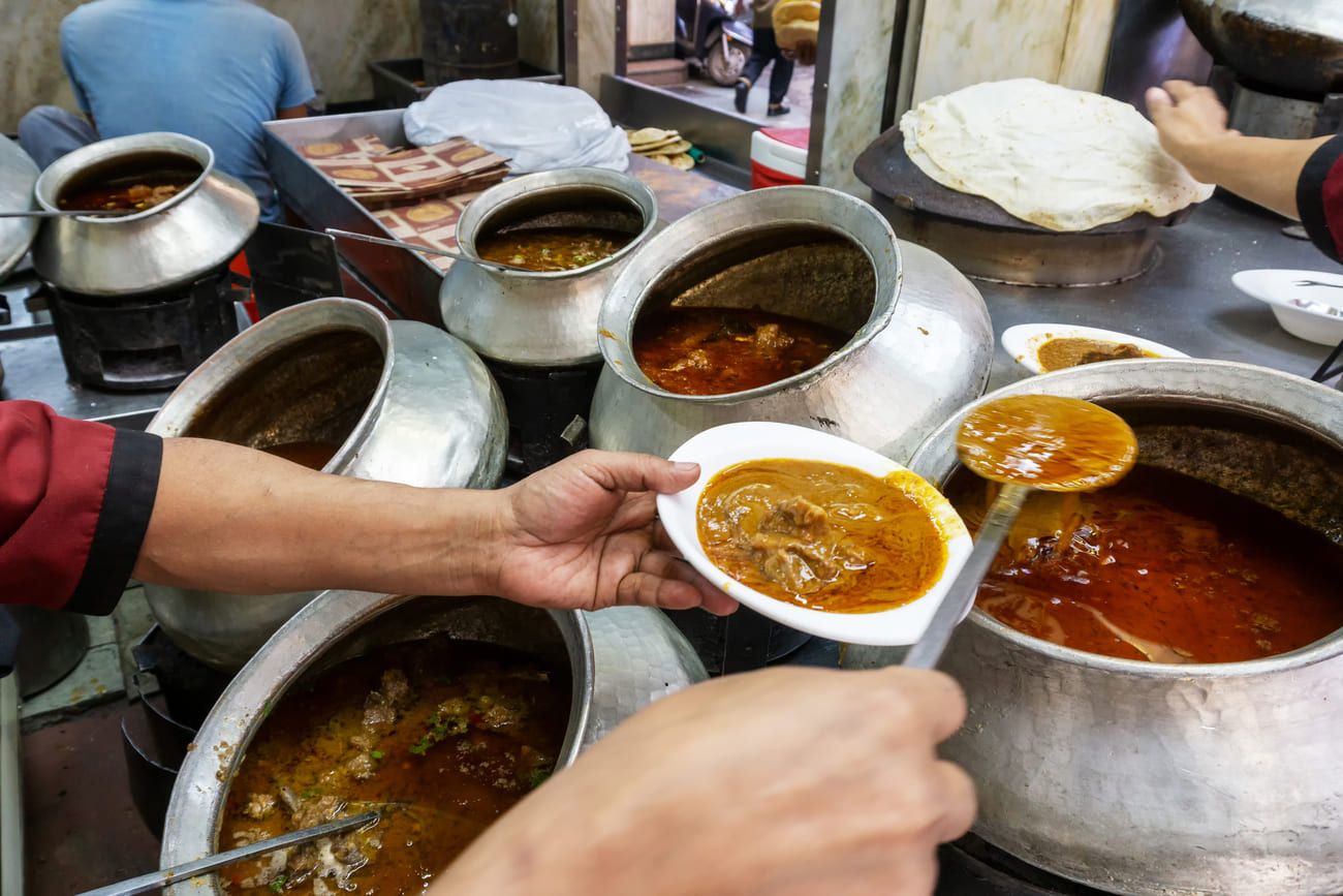 A cook dishing up delicious mutton curry at one of the many restaurants in Chandni Chowk, Old Delhi