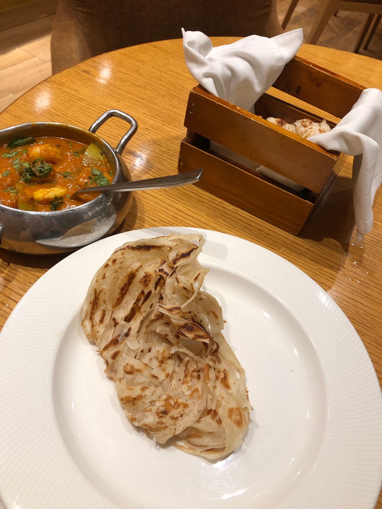 A delicious traditional meal of shrimp and mango curry with parata bread