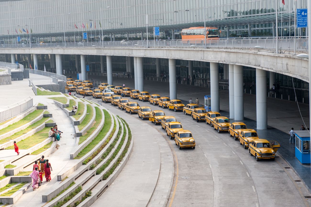 A fleet of the iconic yellow Ambassador taxis waiting outside the Netaji Subash Chandra Bose International Airport in Kolkata. © SIHASAKPRACHUM