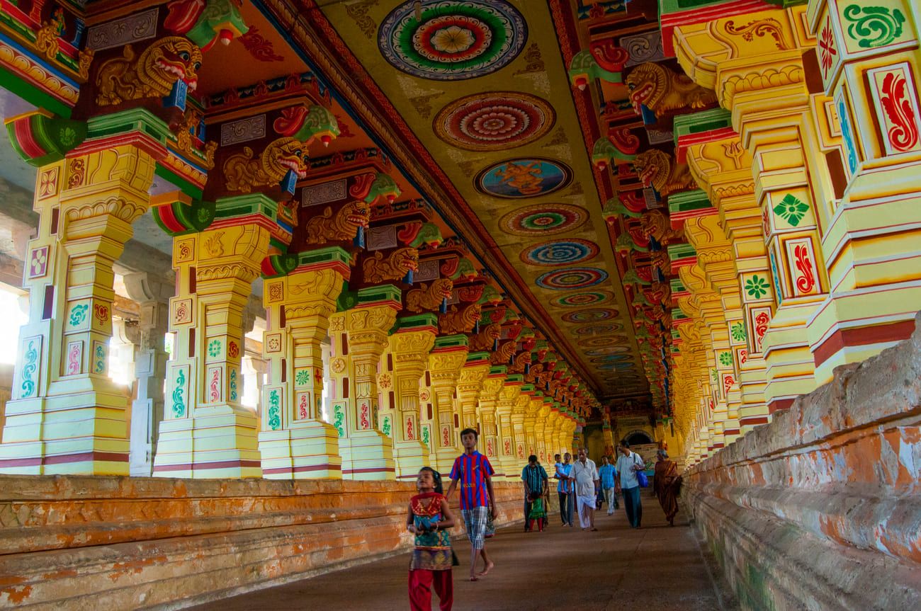 a group of devotees walking through the colorful corridors of ramanathaswamy temple