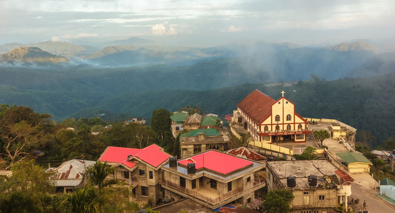 A local church in the city of Lunglei surrounded by a panorama of misty mountains and a view of the valley