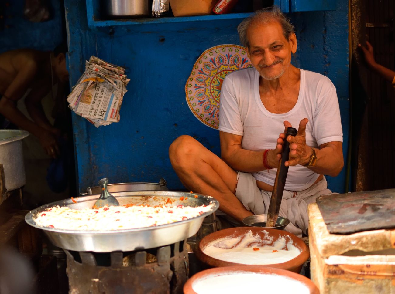 A local vendor prepares curd or doi at his shop which is considered an auspicious sweet 