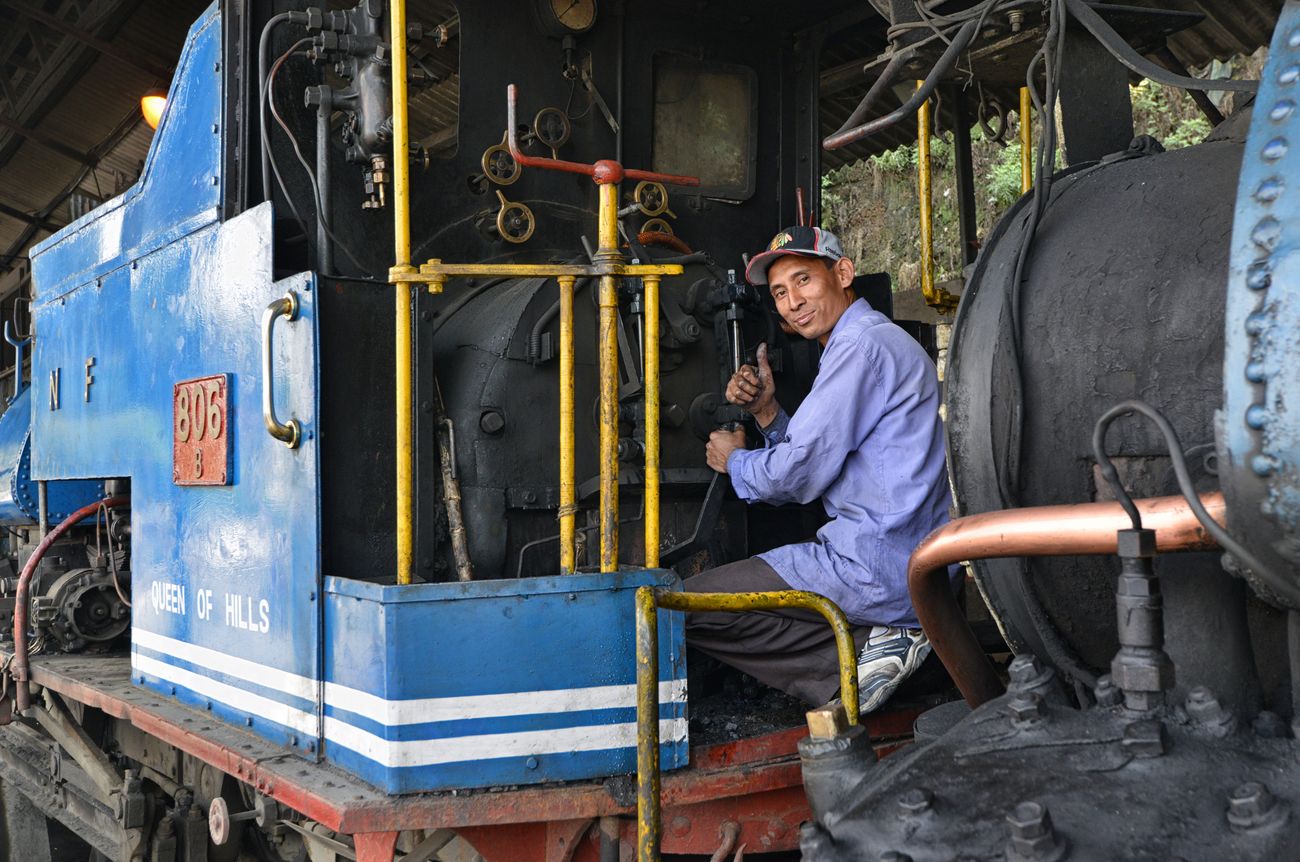 A mechanic checking the engine of the Darjeeling Himalayan Railway Train, lovingly referred to as the Toy Train, to ensure safety of passengers 