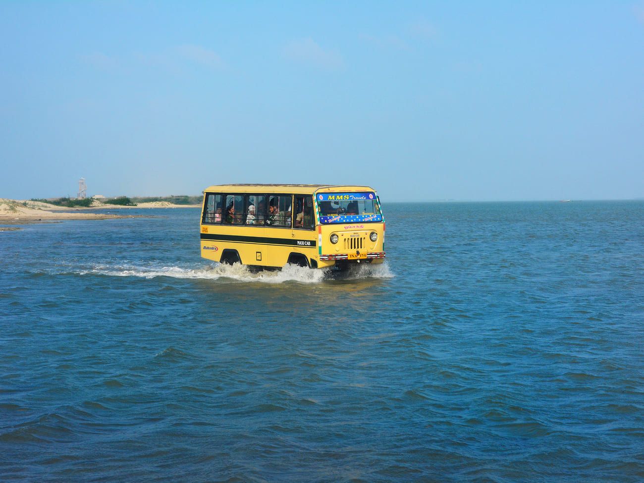 A minibus driving pilgrims on a unique route though the shallow sea to Dhanushkodi
