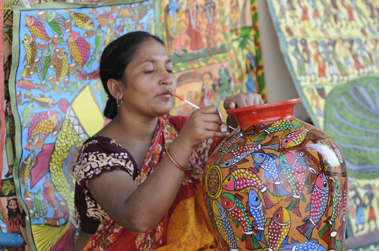 A rural woman paints a pot during the Handicraft Fair in Kolkata 