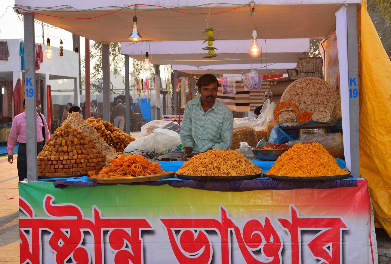 A shopkeeper selling local Indian snack mix at a roadside shop 