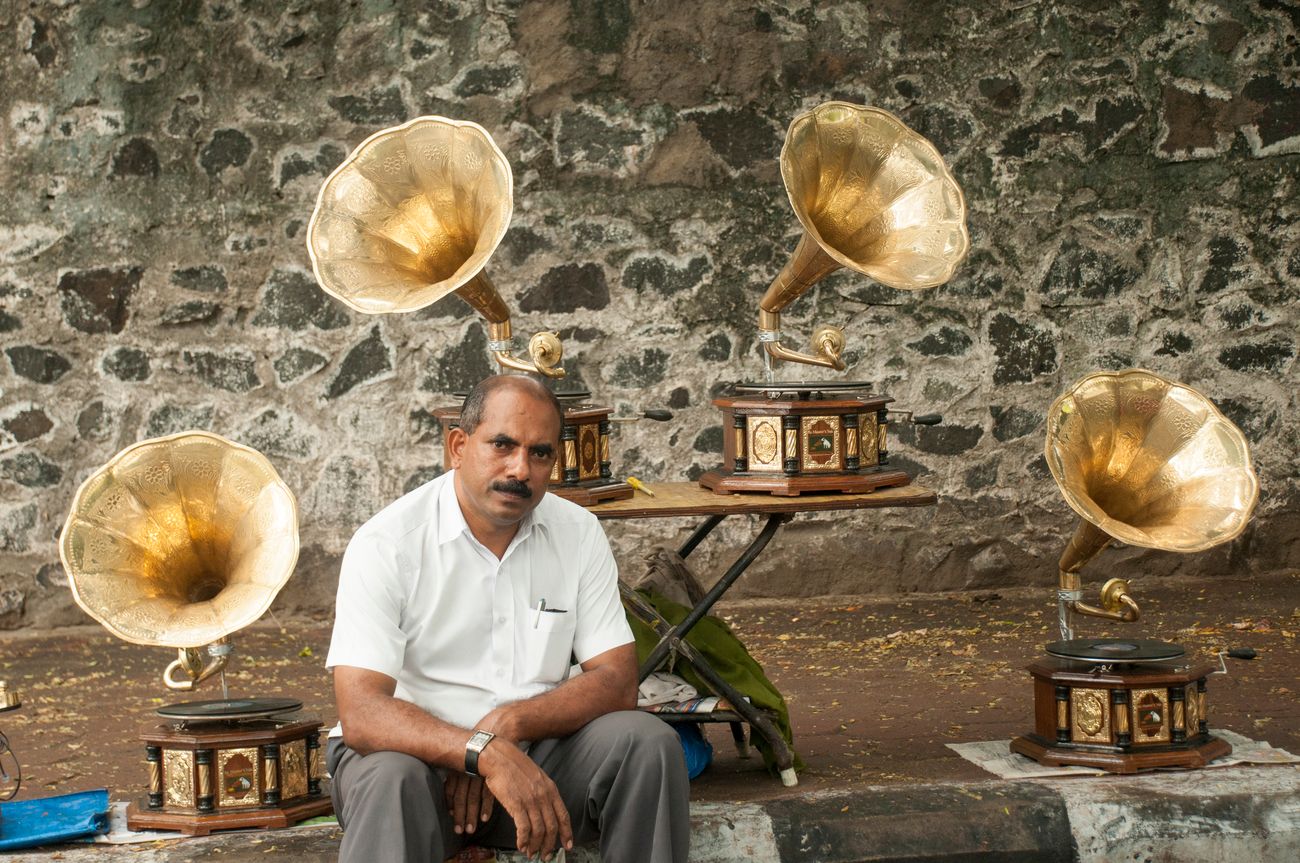 A sidewalk vendor in Chennai displays his beautiful, hand-carved vintage gramophones with their shining brass horns