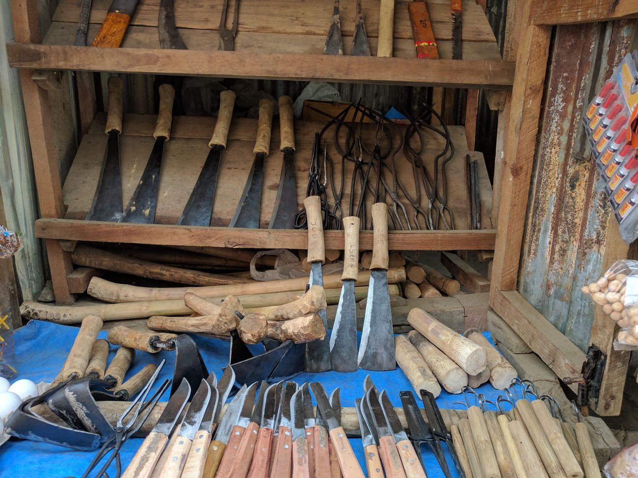 A small shop selling knives, spades, and other blades, as well as offering repairs and sharpening for locals at a market in Champhai