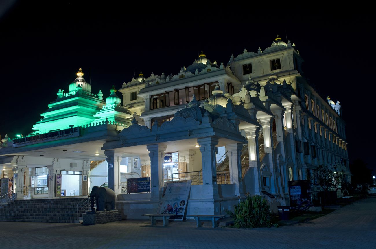 A stone elephant silently stands watch at the entrance of the imposing International Society for Krishna Consciousness (ISKCON) building.