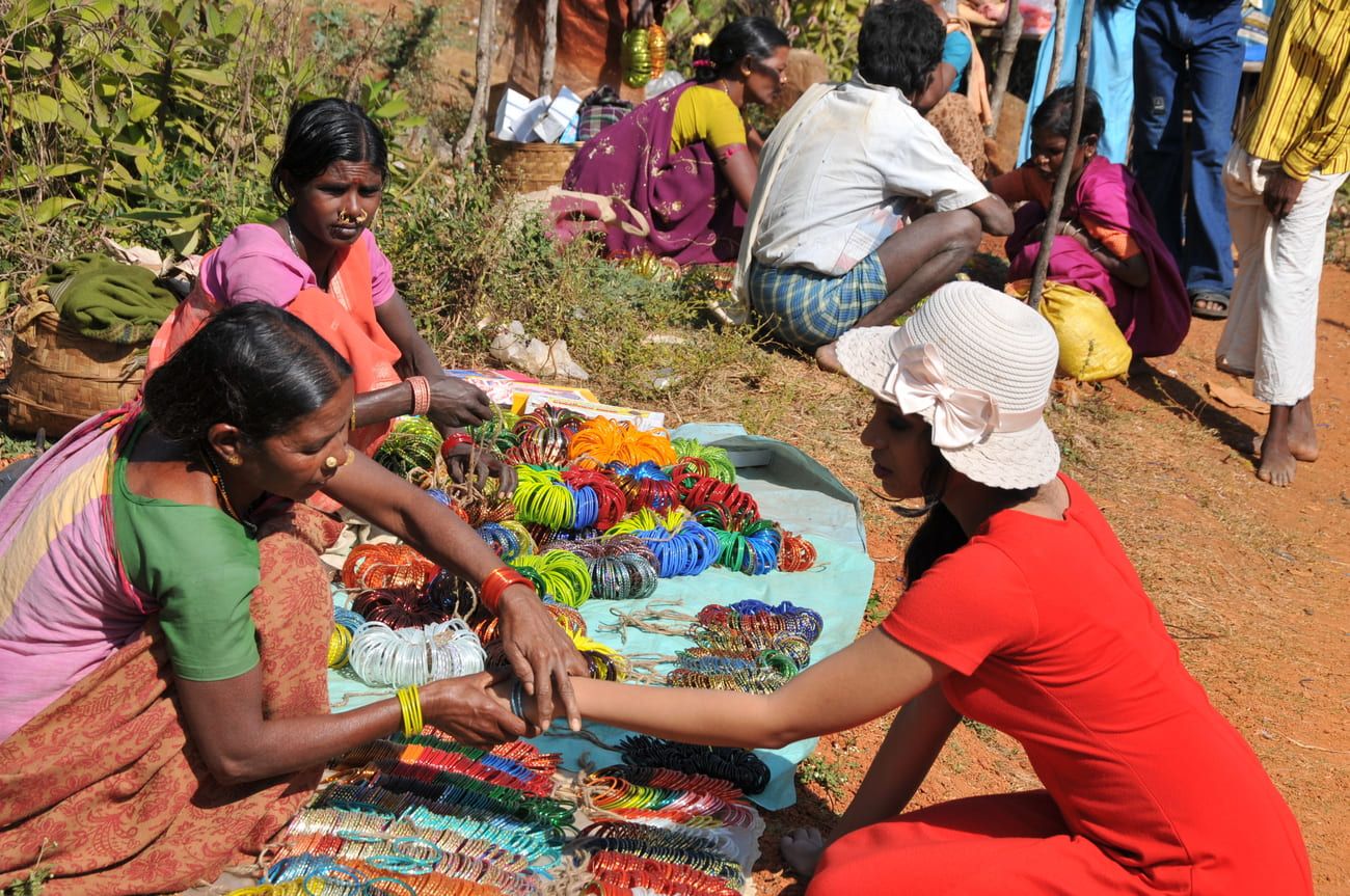 A tourist buys colorful bangles from a local roadside vendor in Araku 